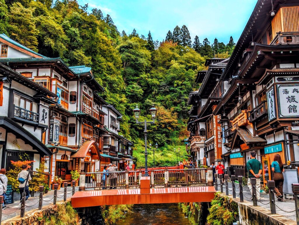 Iconic Taisho-era ryokans and red bridge in Ginzan Onsen.